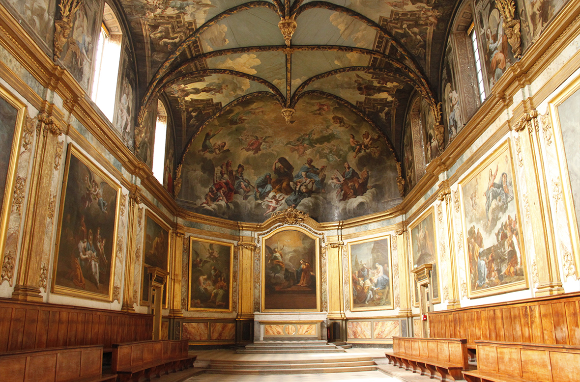 Large room covered in paintings from floor to ceiling with golden frames and wood panelling